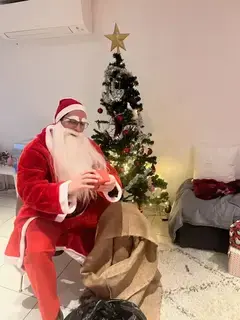 Tomte sitter på stol och läser paket