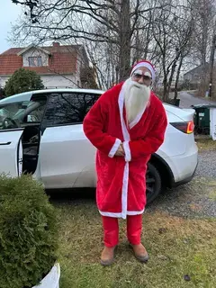 Tomte poserar framför bil